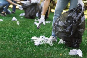 Young volunteers collecting garbage in suumer park